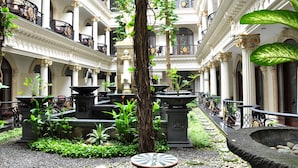 A courtyard with a central fountain, surrounded by columns and potted plants. - The Grand Palace Hotel Malang (Malang)
