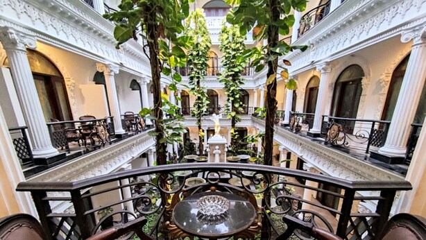 A grand interior with ornate columns, a central fountain, and a view of the courtyard. - The Grand Palace Hotel Malang (Malang)