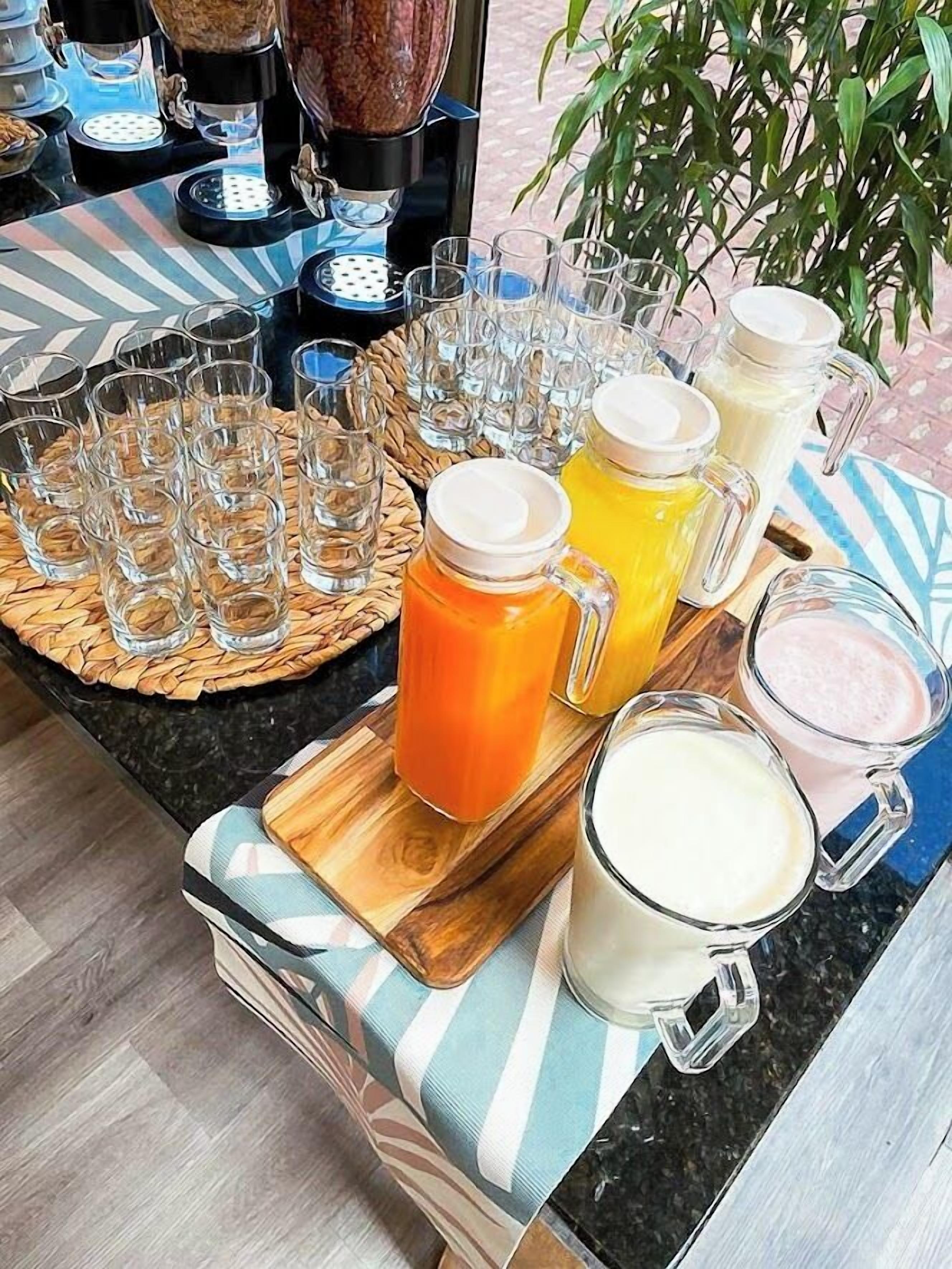 En morgenmadsbuffet med forskellige drikkevarer og en kaffemaskine.