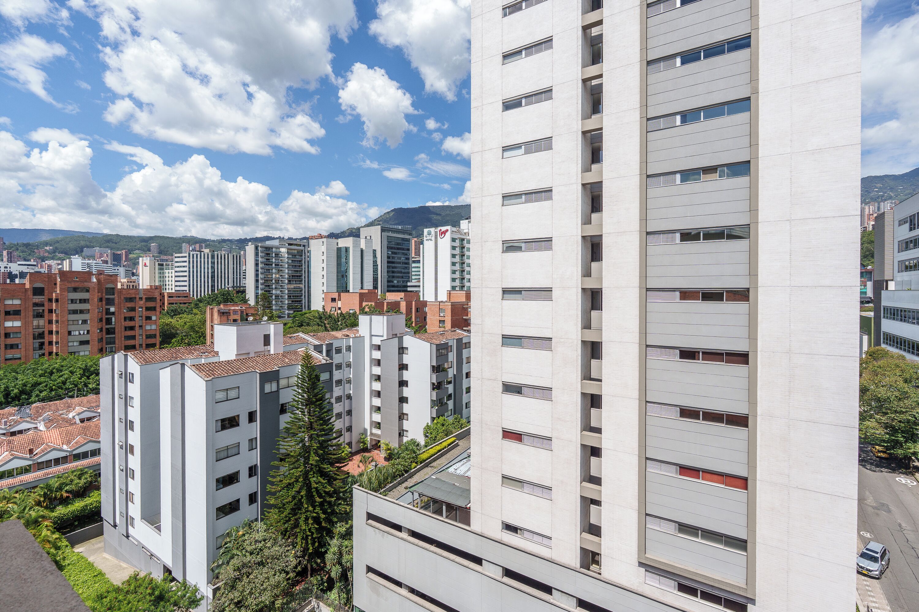 Ein Hochhaus mit mehreren Stockwerken, großen Fenstern und einem modernen architektonischen Design.