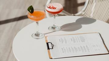 Two drinks on a white table with a menu.