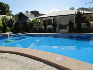 A swimming pool with a clear blue water surface, surrounded by a stone deck. - Seashore Beach Resort (Puerto Galera)