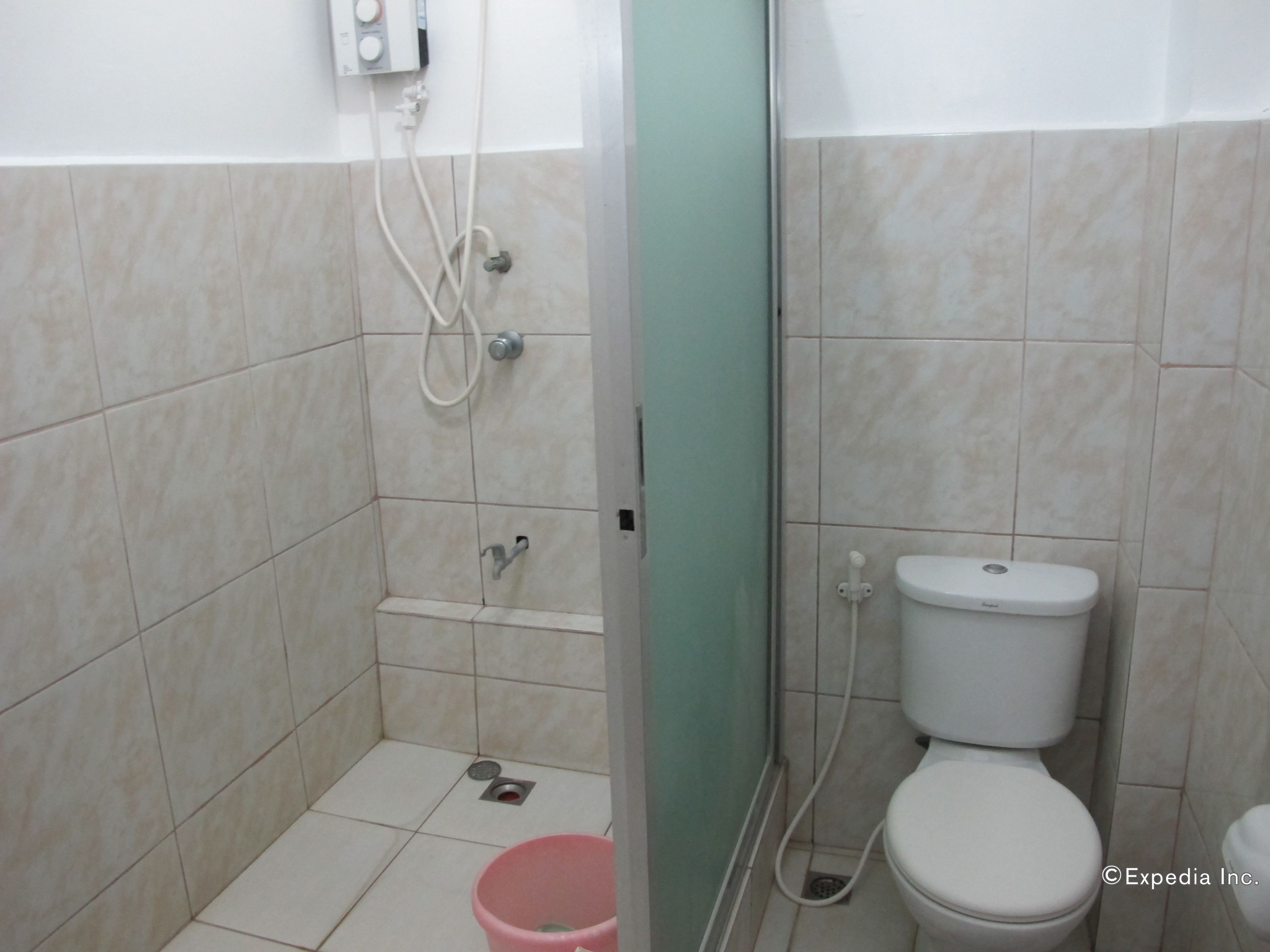 Une petite salle de bain avec des toilettes, une douche et un lavabo.
