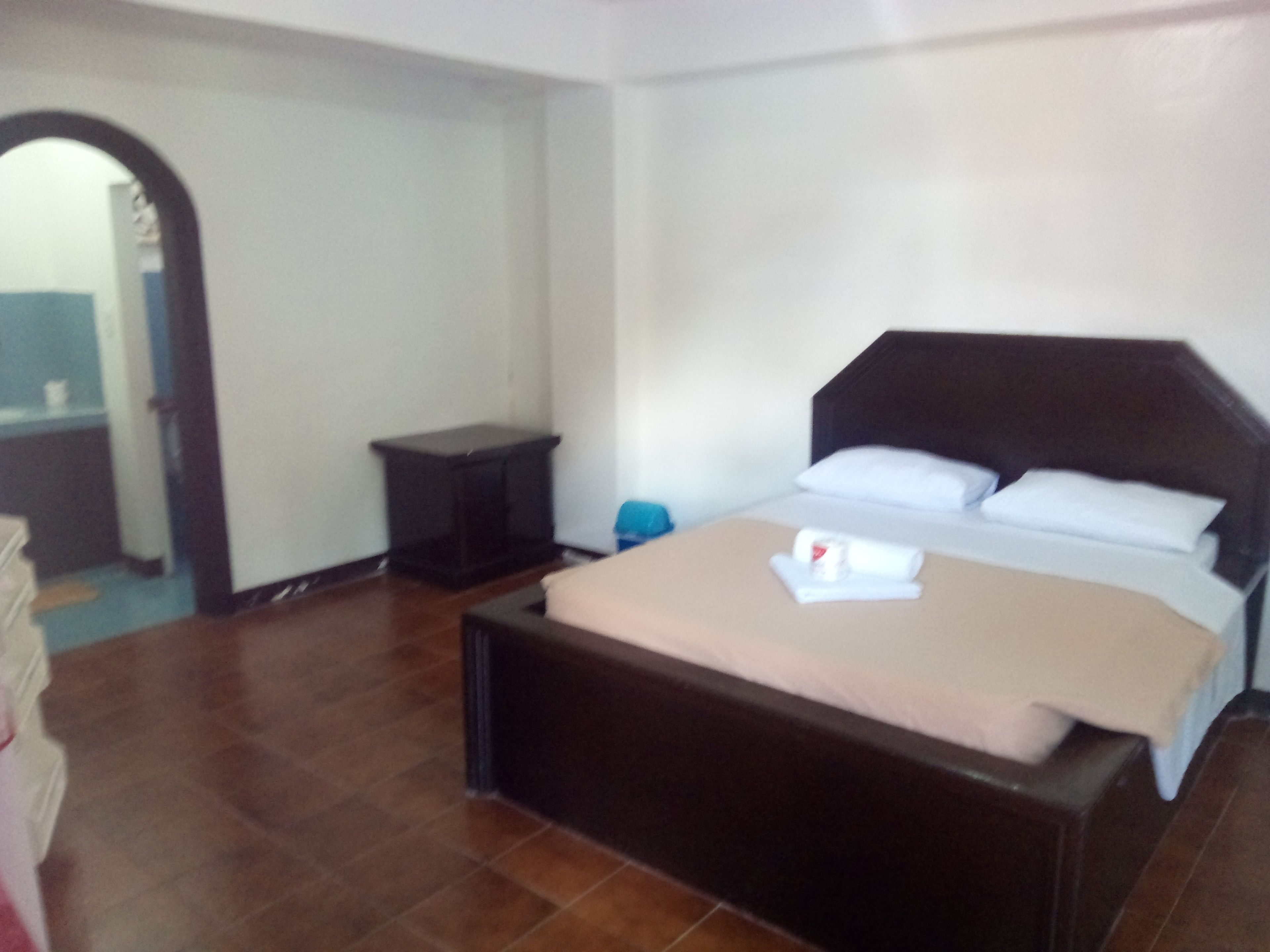 A bedroom with a bed, a bedside table, and a small nightstand.
