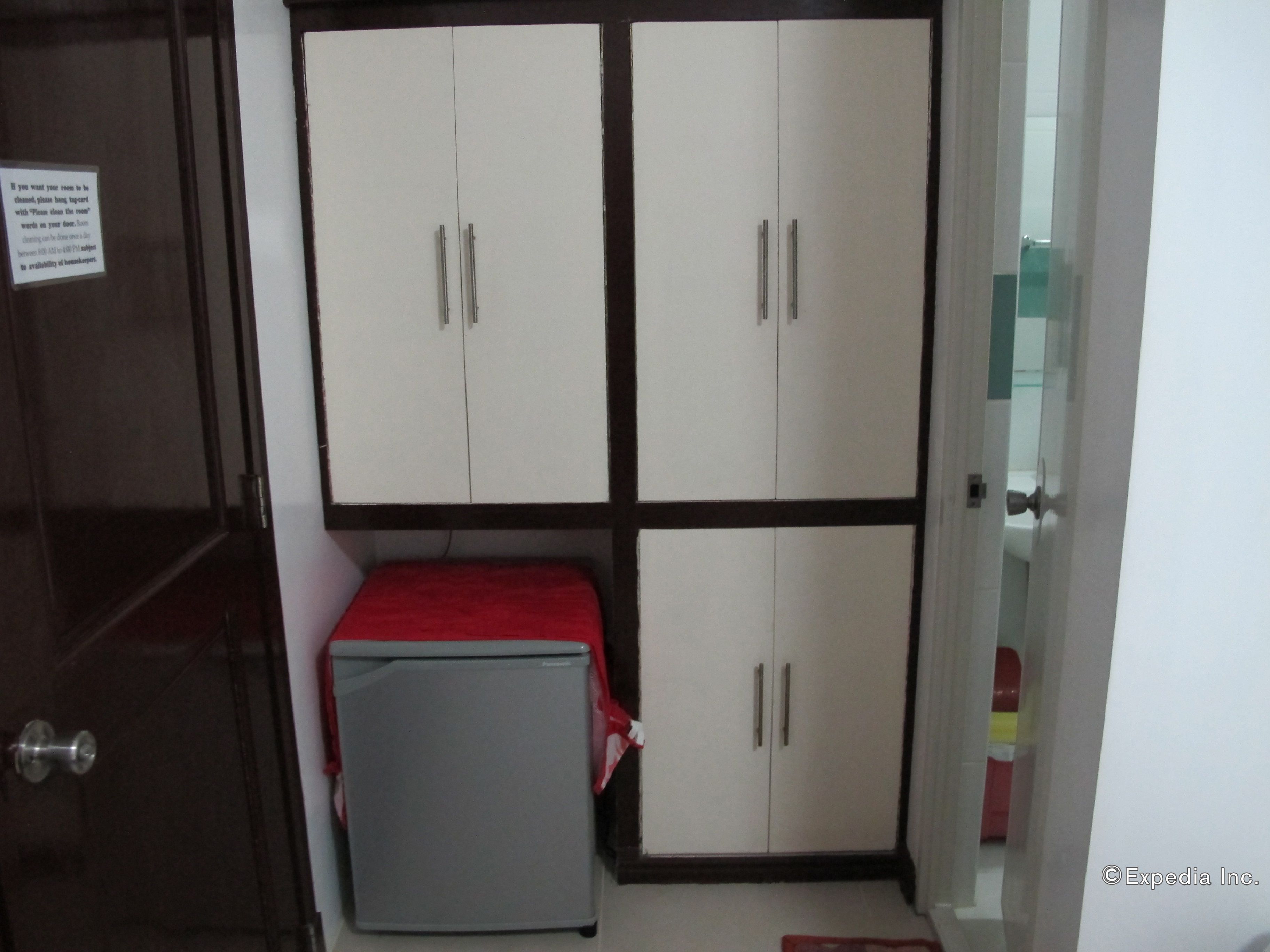 A room with a bed, a small table, and a wardrobe with four doors.