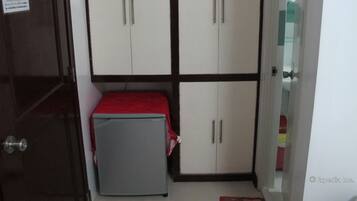 A room with a bed, a small table, and a wardrobe with four doors.