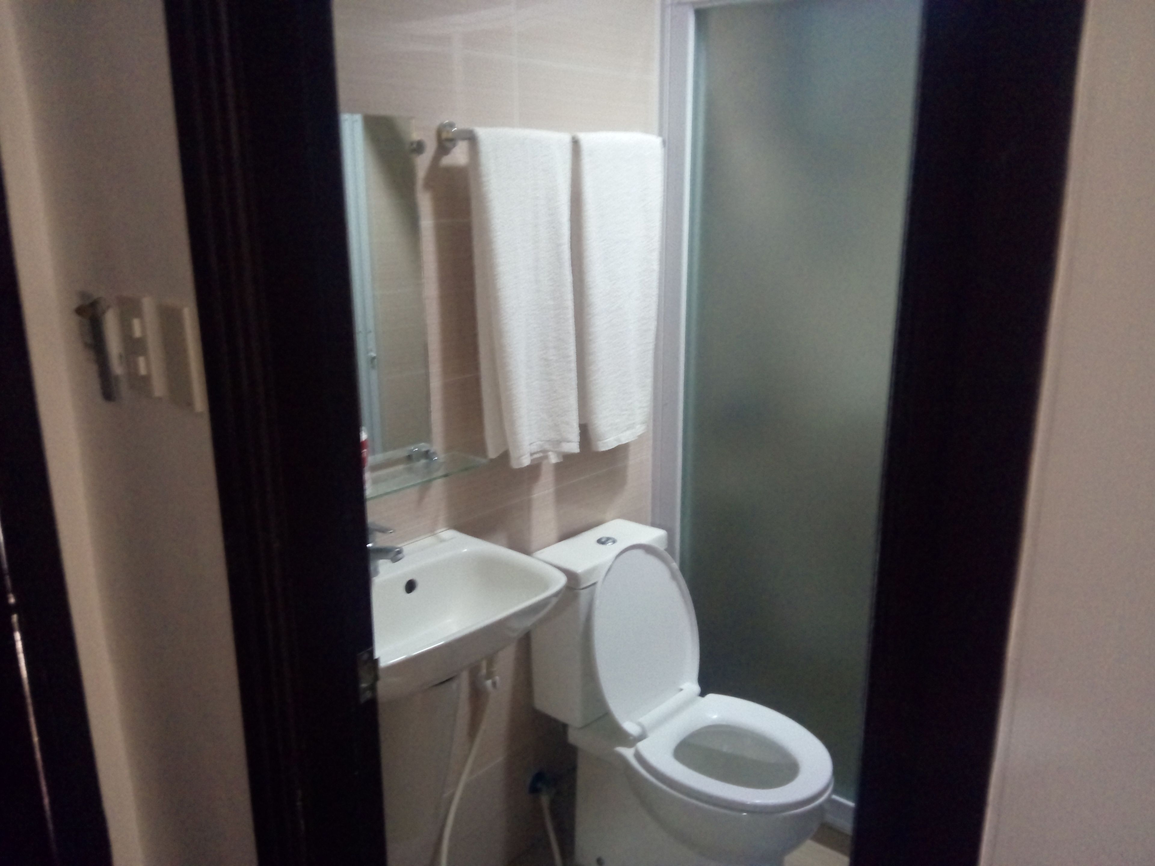 Un baño con inodoro, lavamanos y cabina de ducha de vidrio.