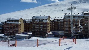 Un hôtel à étages, avec un télésiège et des environs enneigés.