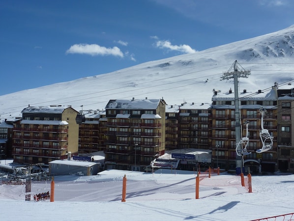 A hotel with multiple floors, ski lift, and snow-covered surroundings.