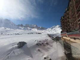 A snow-covered mountain landscape with a building featuring balconies and large windows.