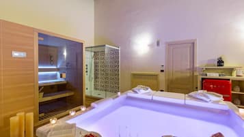 Relax in a serene spa room with a large hot tub, glass-enclosed shower, and cozy seating area.