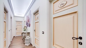 A hallway with cream-colored doors, a white ceiling, and a wooden floor. - Lunaria Suites Rome (Rome)