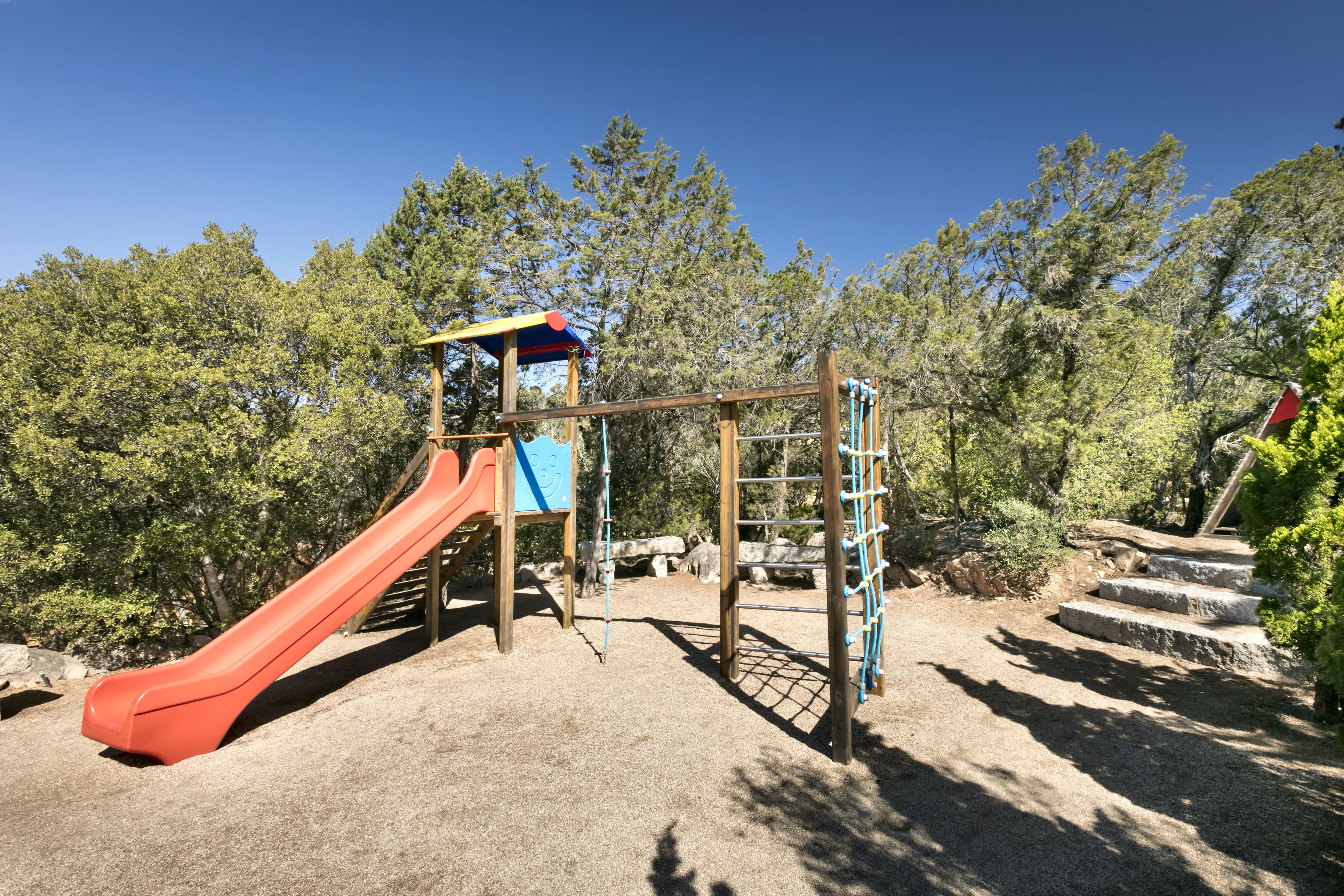 A playground with a slide, climbing structures, and a covered play area.