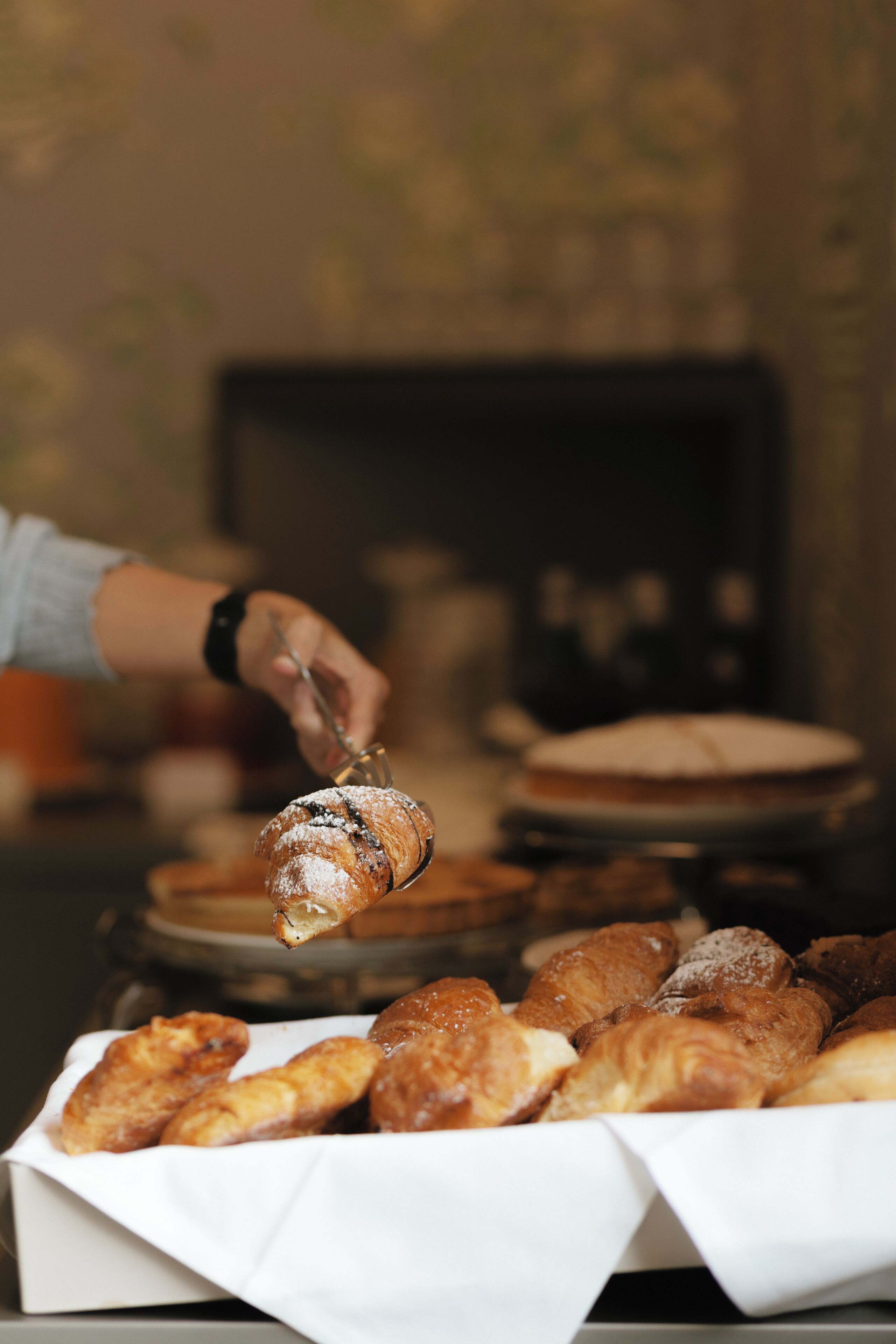 A tray of pastries with one being picked up.