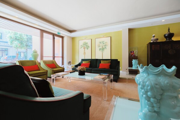 A hotel lobby with a green sofa, two armchairs, a coffee table, and a decorative vase. - Hotel Miramare (Civitanova Marche)