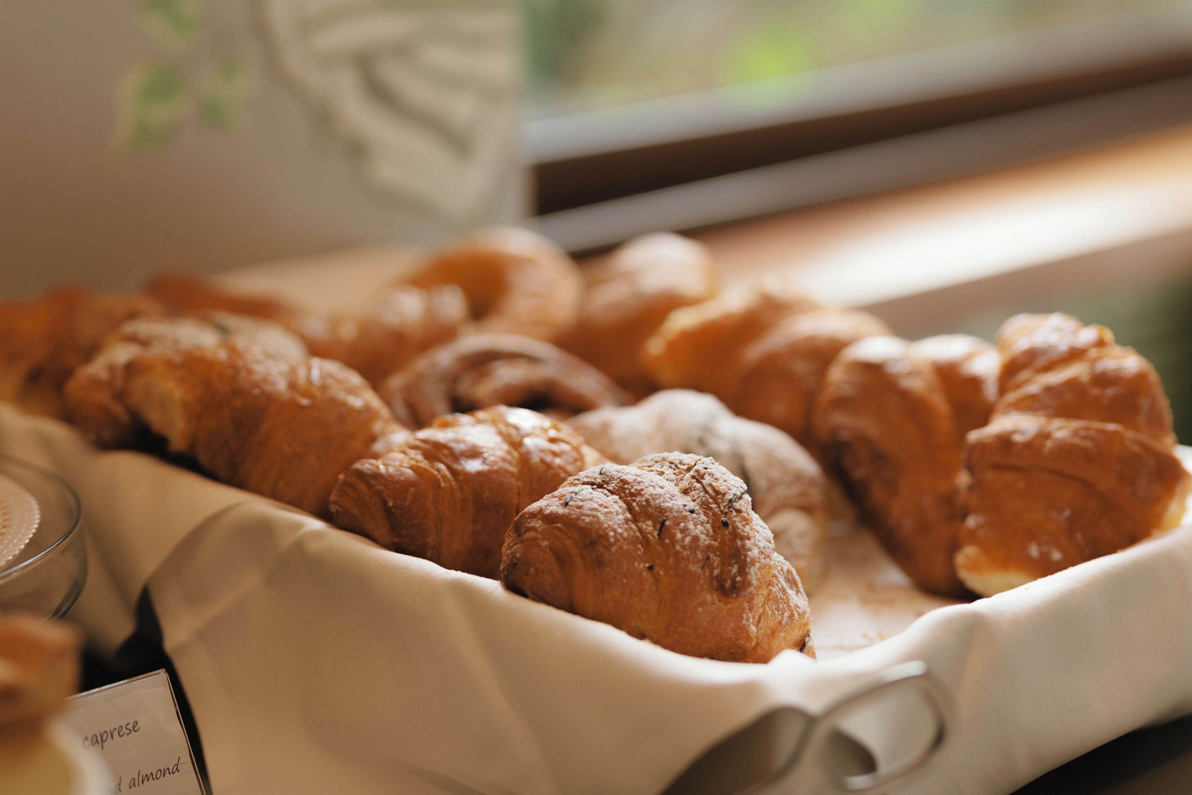 A tray of assorted pastries, including croissants, on a table.