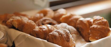 A tray of assorted pastries, including croissants, on a table.