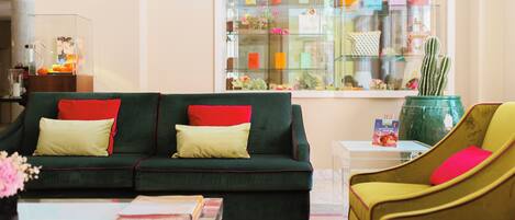 A living room with a green sofa, a yellow armchair, and a glass coffee table.