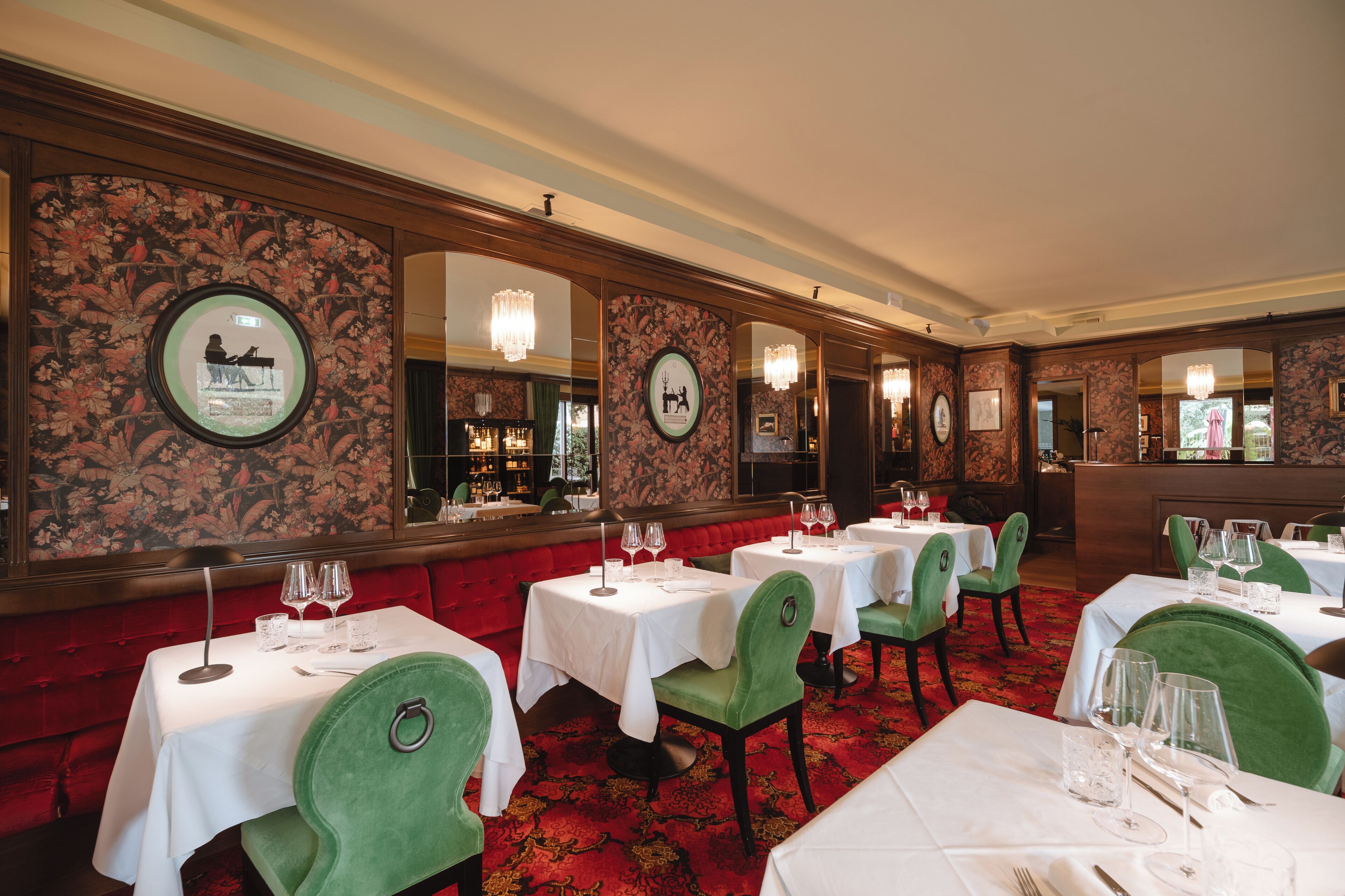 A formal dining room with multiple tables and chairs, each set with wine glasses and cutlery.
