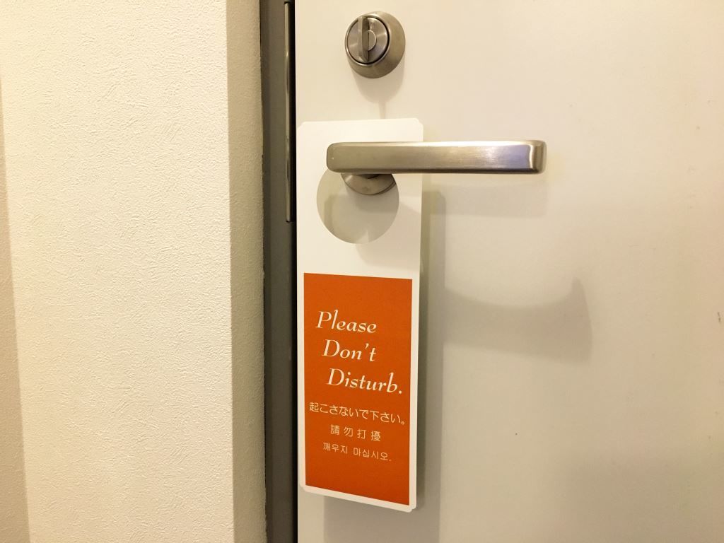 Una porta con un cartello che riporta la scritta 'Non disturbare'.