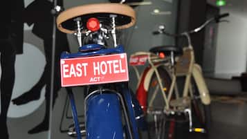 A bicycle with a sign that reads "EAST HOTEL ACT."