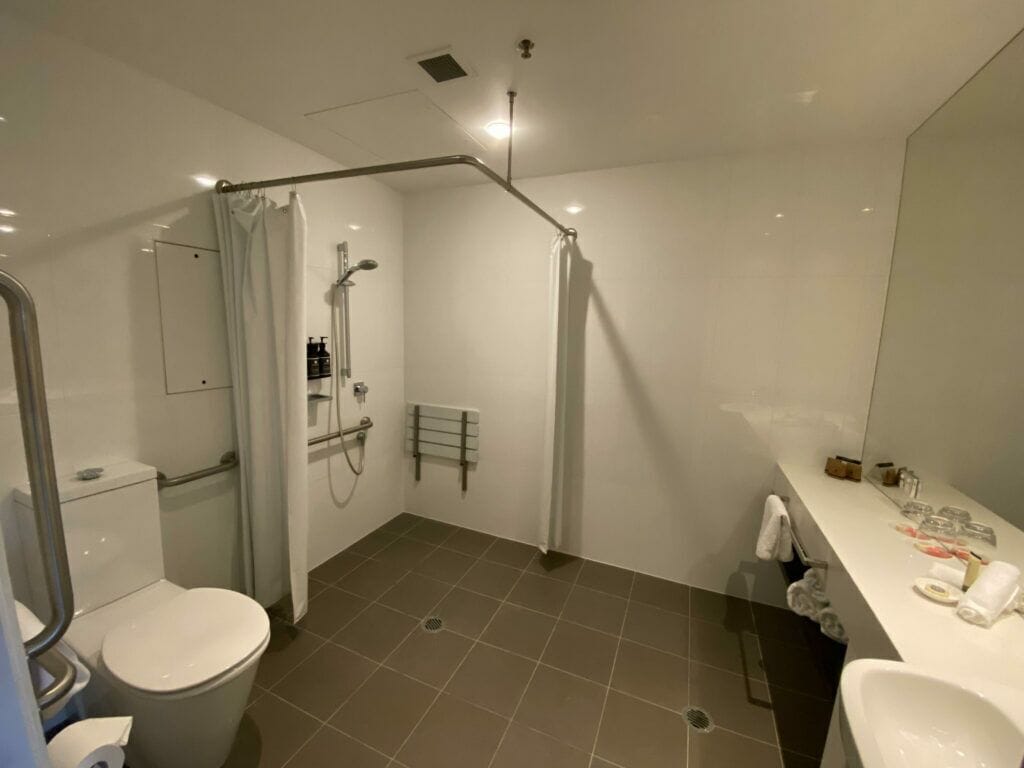 A modern bathroom with a shower, toilet, and sink.