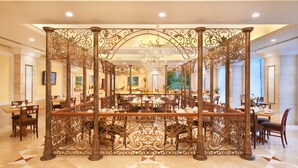A spacious dining area with a central ornate partition, chandeliers, and a polished floor. - Accord Puducherry (Puducherry)