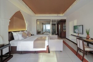 Habitación de hotel moderna con una cama grande, un escritorio, una silla y un televisor.