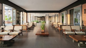 A spacious indoor area with rows of seating and a central wooden table, large windows, and a view of the outside. - Muine Bay Resort (Mui Ne)