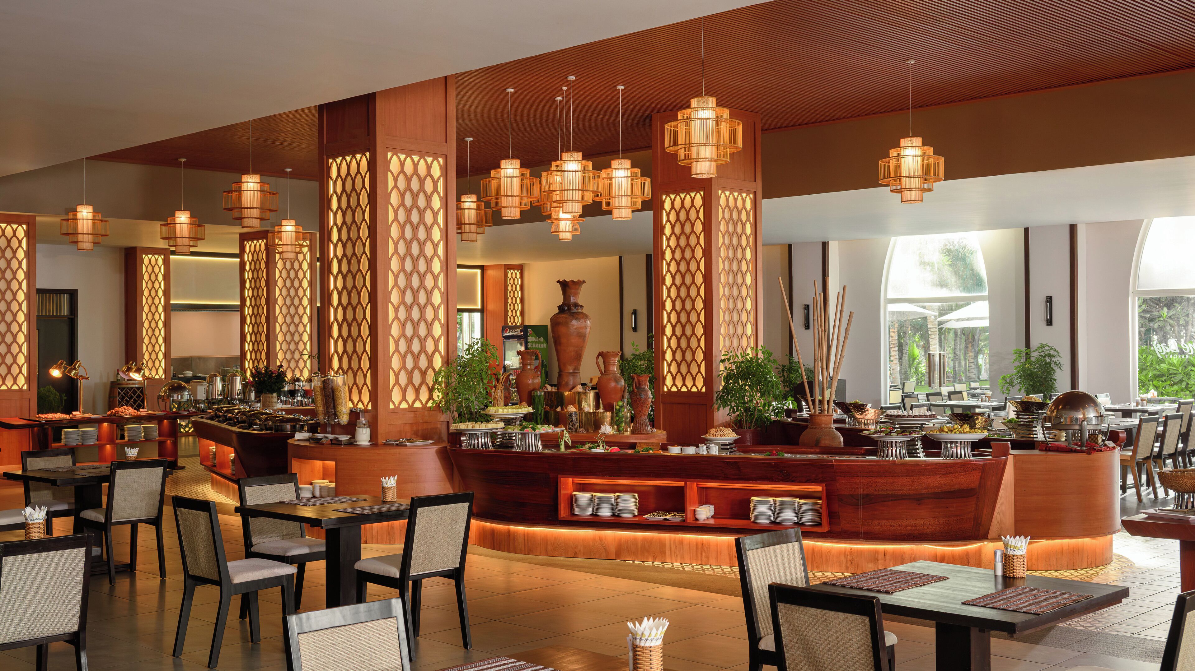 A restaurant with wooden decor, hanging lights, and a buffet setup.