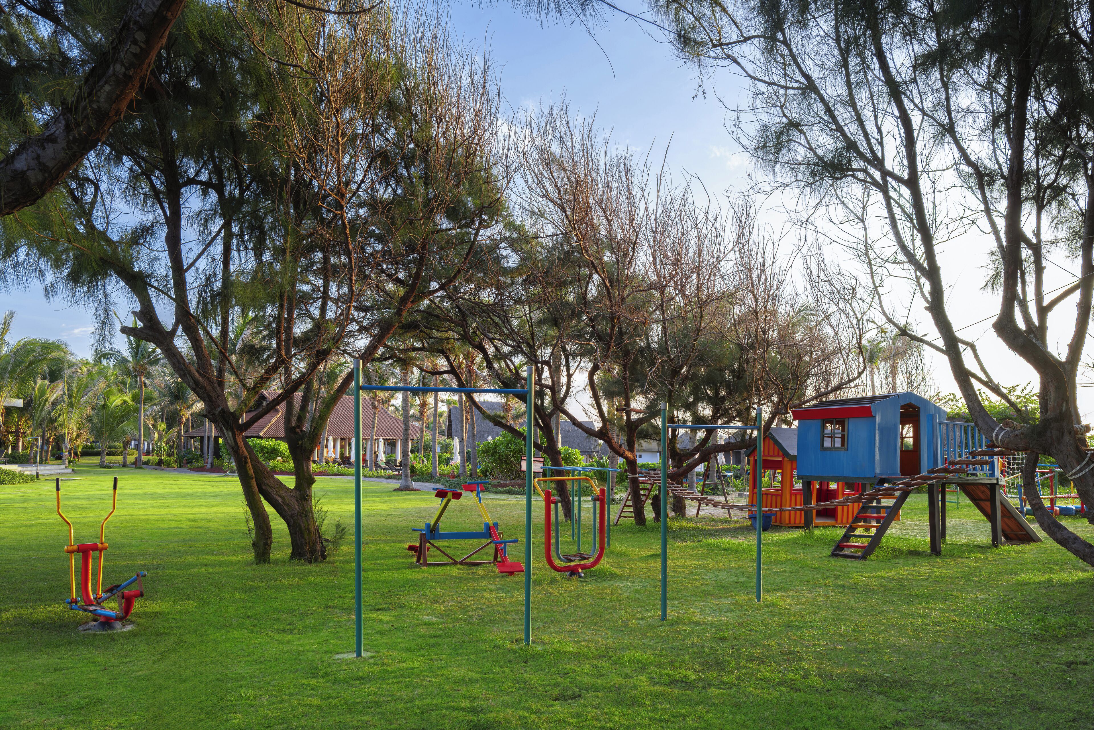 A playground with swings, a slide, and a climbing structure.