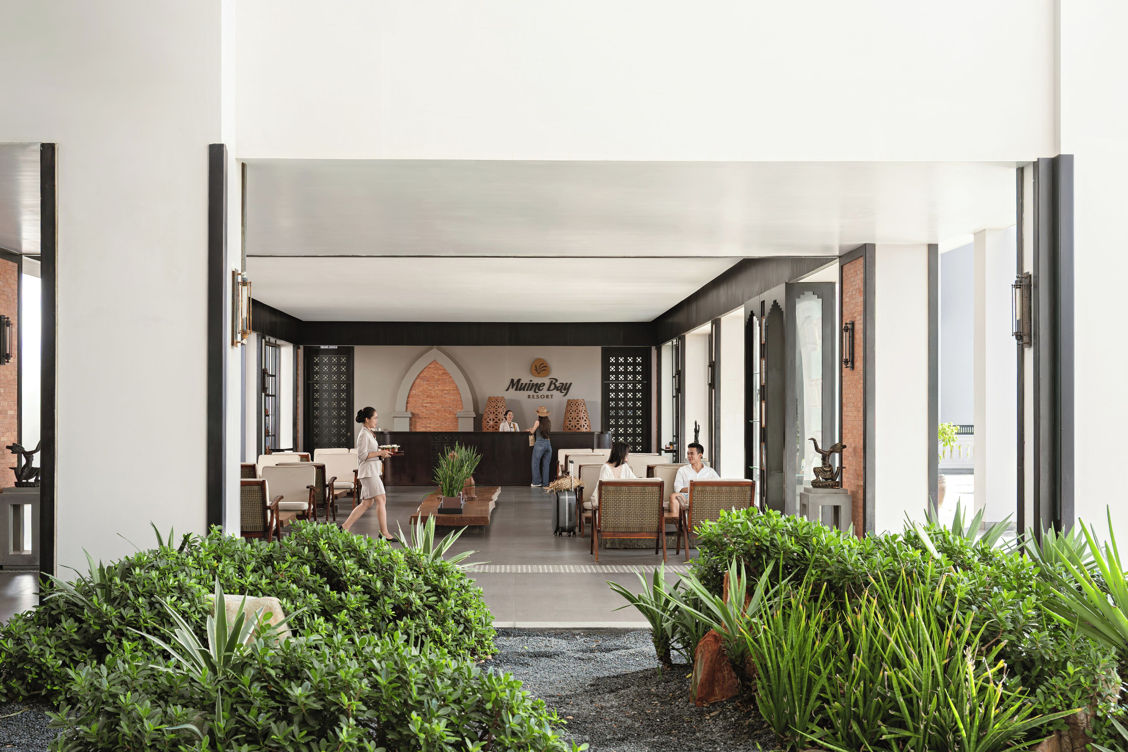 A reception area with a reception desk, seating, and a sign for 'Muine Bay Resort'.