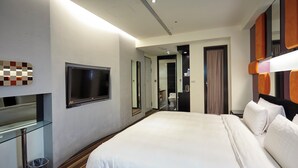 A hotel room with a large bed, a television, a mirror, and a small table. - Hotel G7 Taipei (New Taipei City)