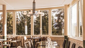 Une salle de conférence avec une longue table, des chaises et un lustre.