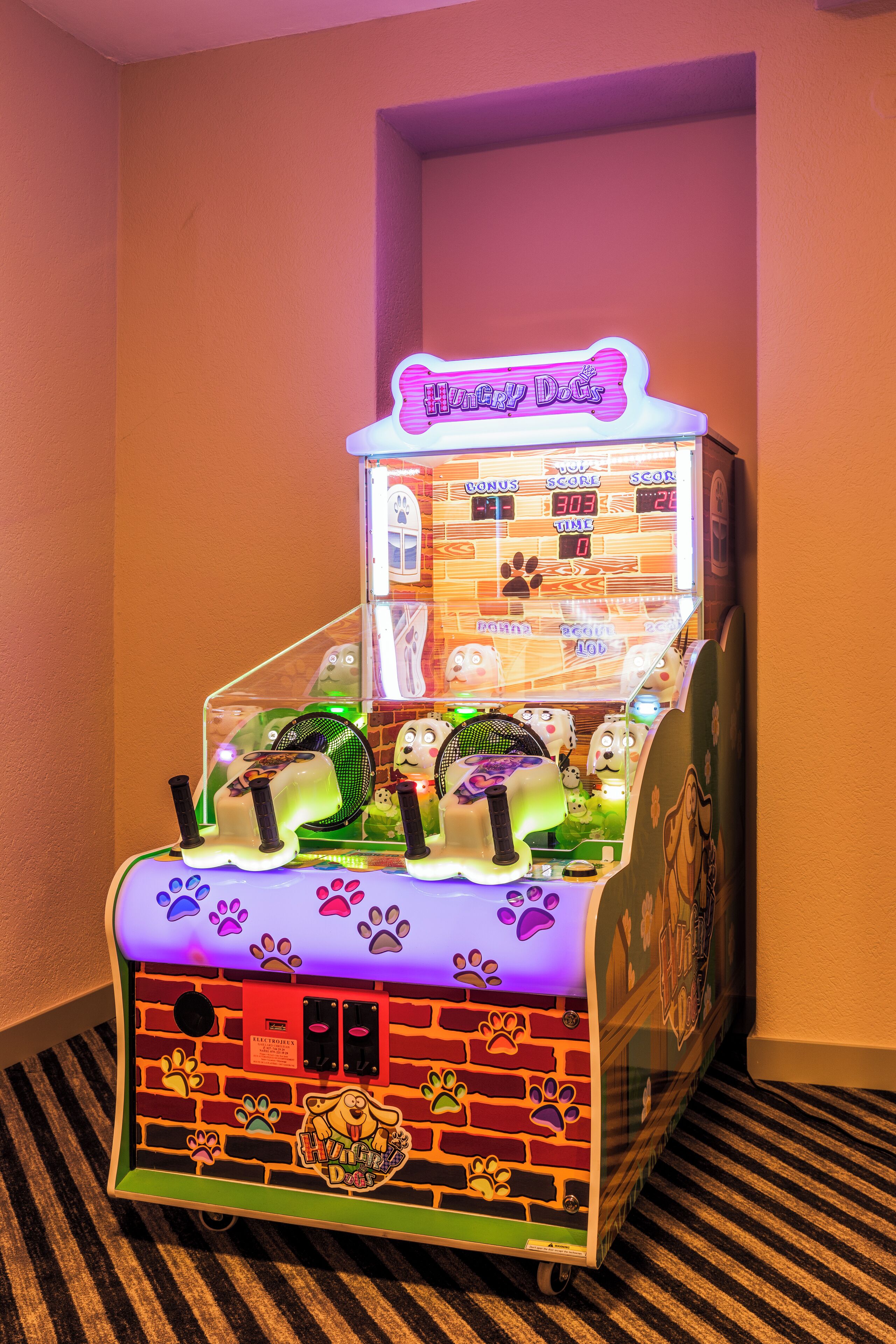 Juego de arcade tipo garra con diseño de ladrillos y adornos de huellas de patas.