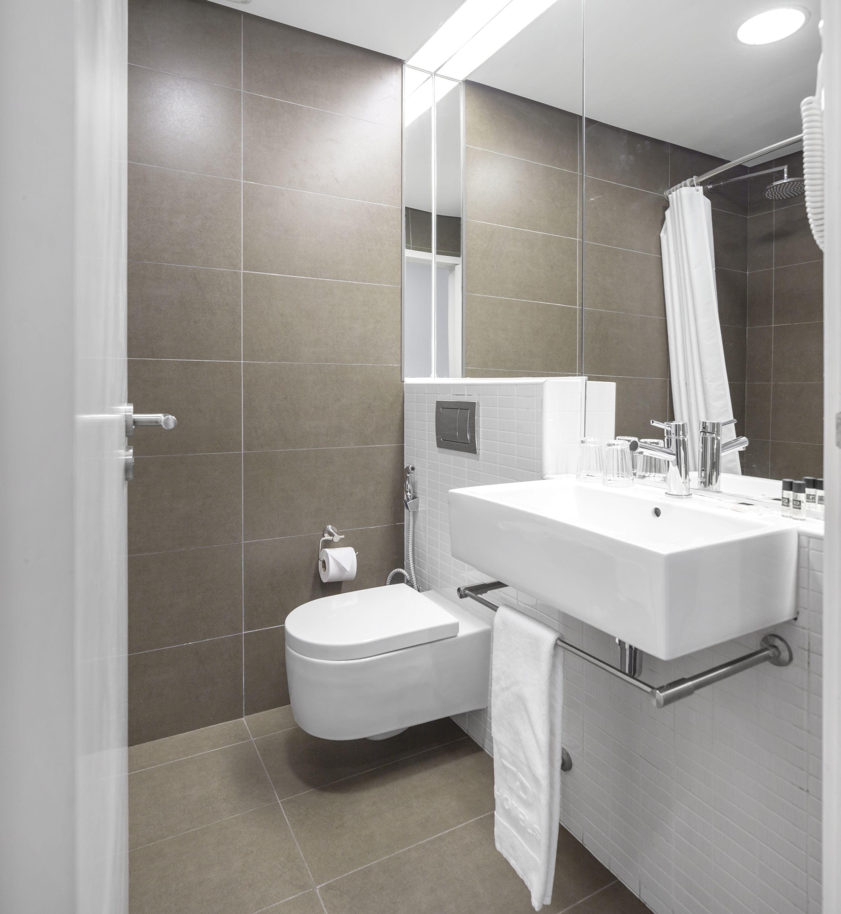 A modern bathroom with a toilet, sink, and shower.