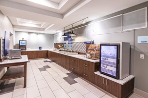 A modern kitchen area with a digital menu display, a coffee machine, and a refrigerator. - Holiday Inn Express & Suites Austin NW - Lakeway by IHG (Lakeway)