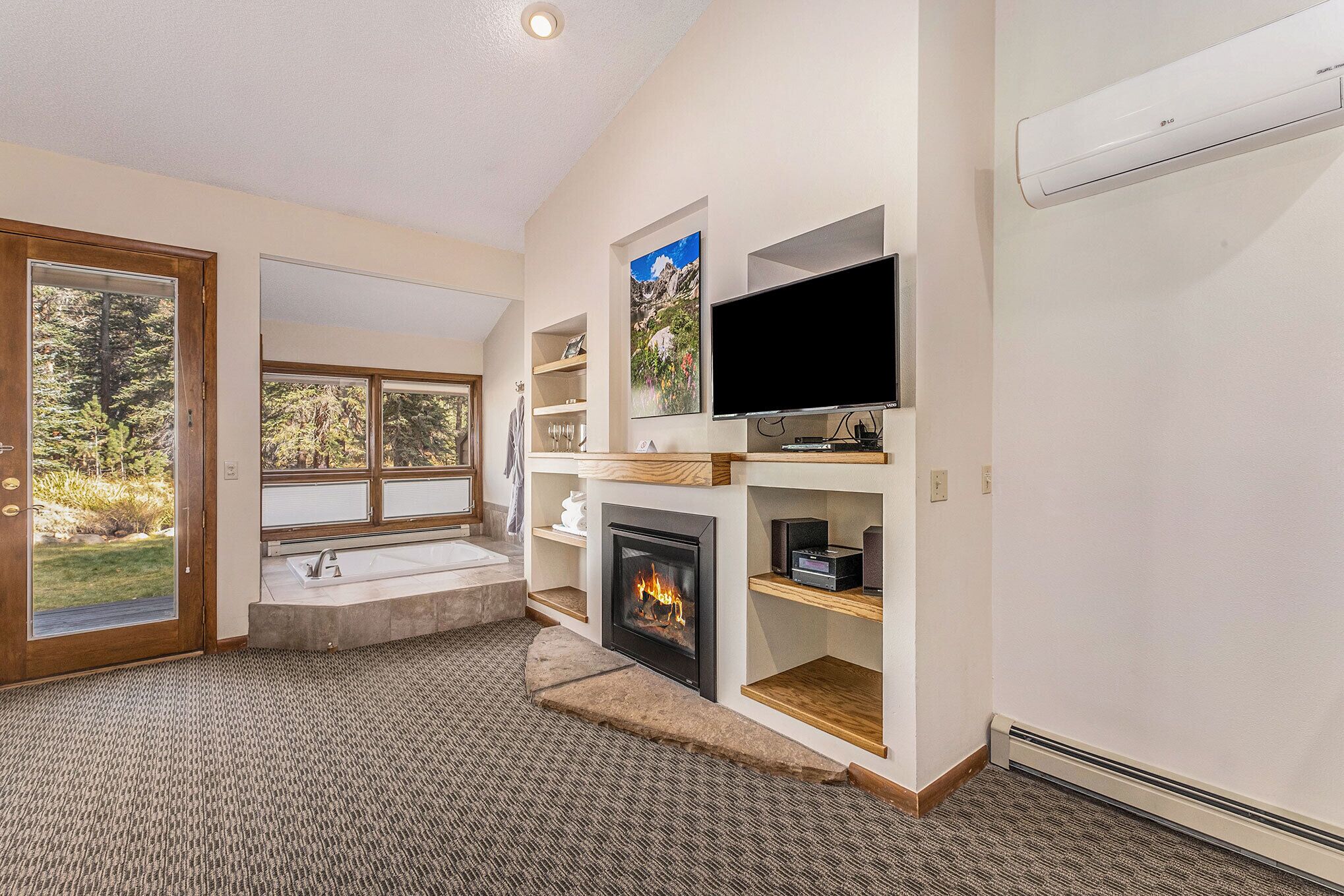 Una sala de estar moderna con chimenea, televisor y estanterías empotradas.