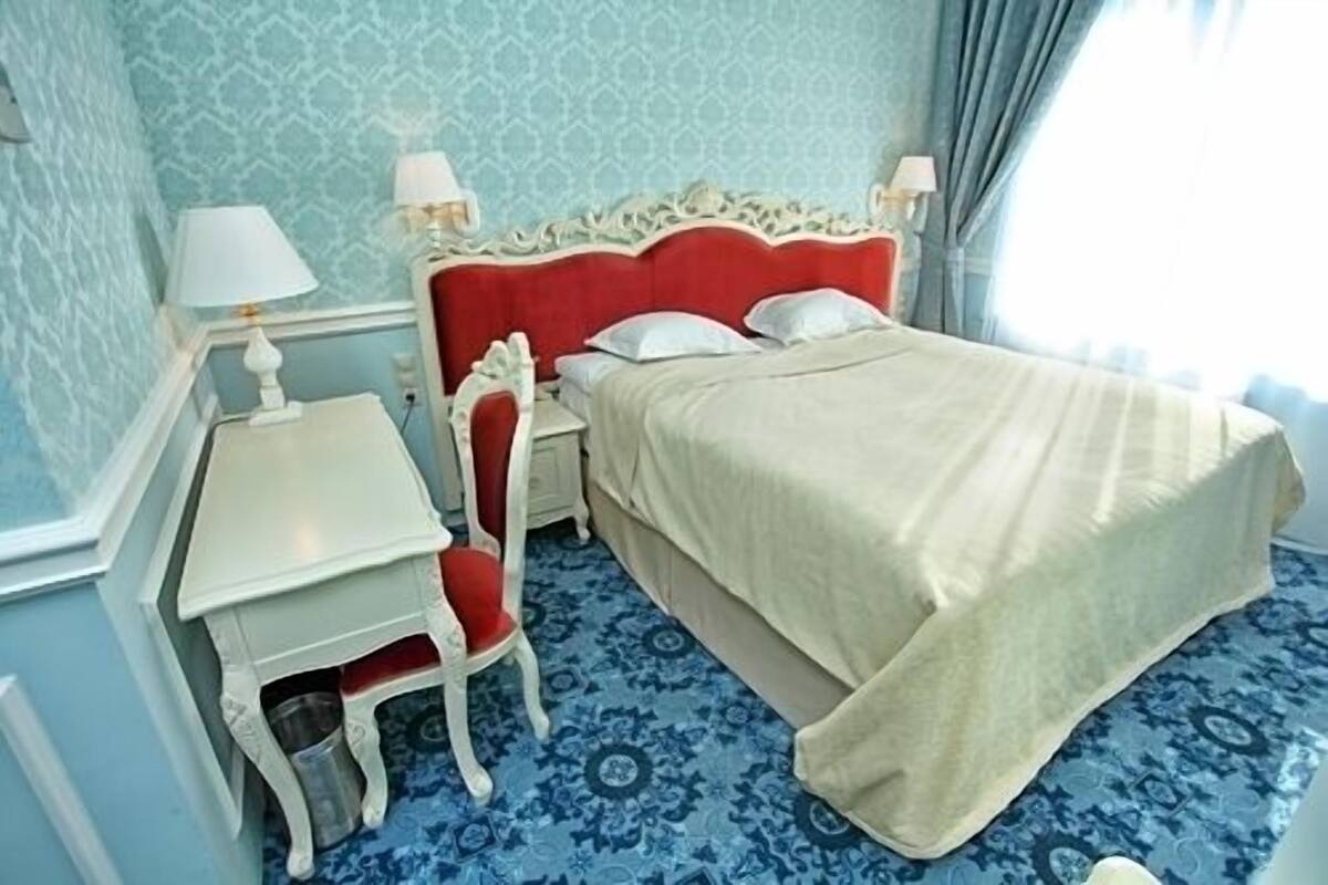 A hotel room with a bed, a desk, and a chair.