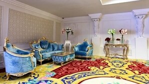 A room with ornate blue sofas, a patterned carpet, and decorative vases. - Royal Congress Hotel (Kyiv)