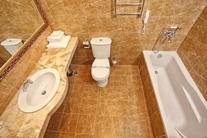 Une salle de bain avec un lavabo, des toilettes et une baignoire.