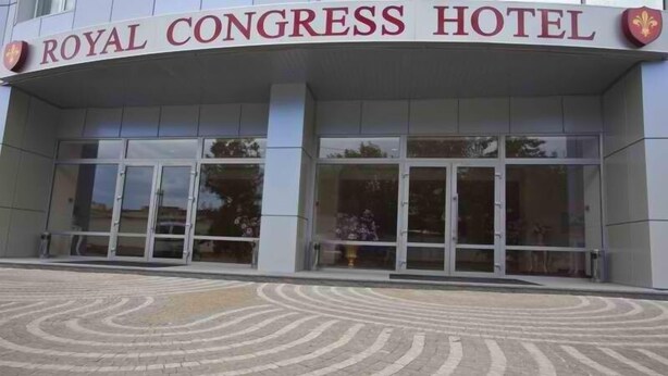 The exterior of the Royal Congress Hotel with a symmetrical facade, large glass doors, and a patterned pavement in front. - Royal Congress Hotel (Kyiv)