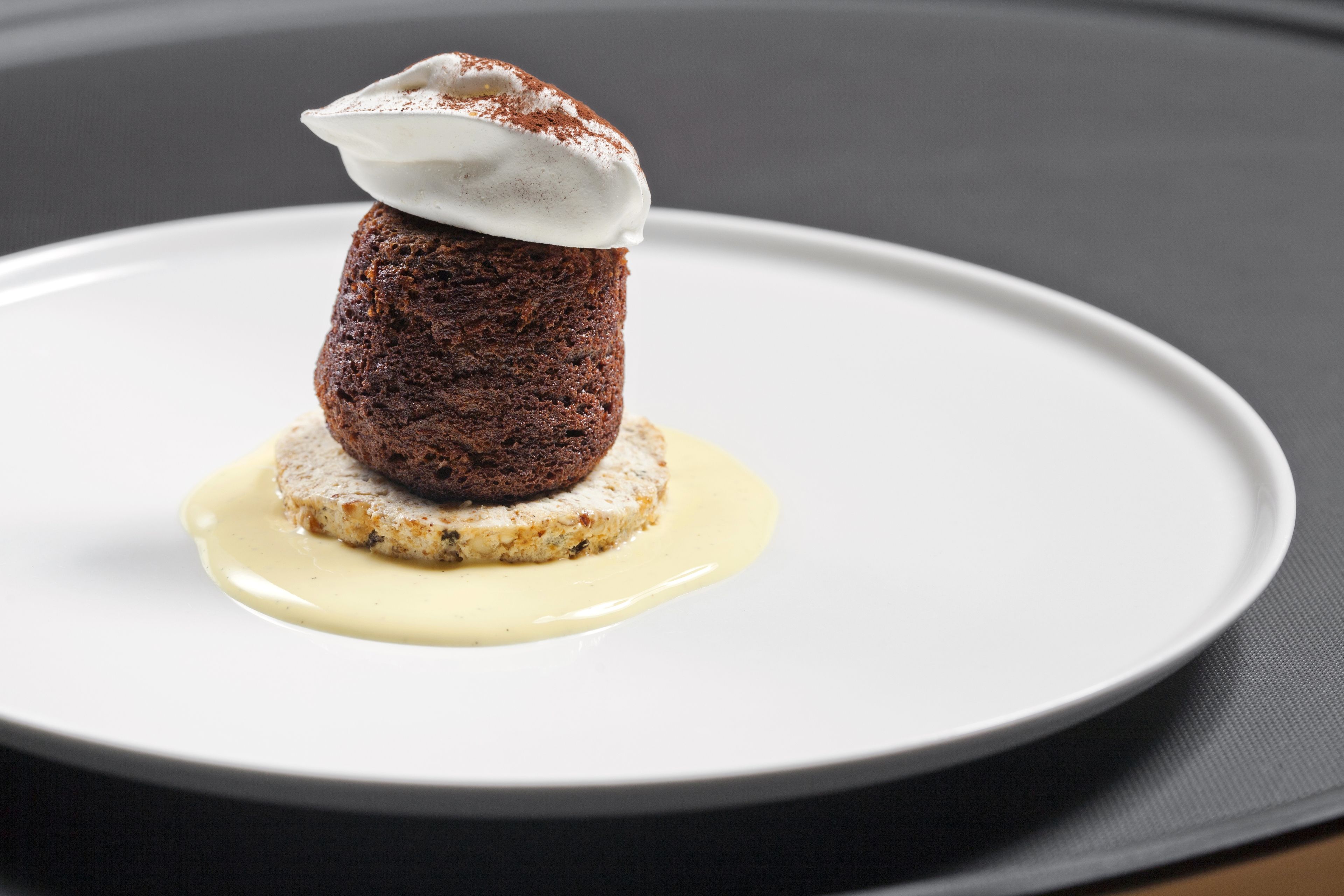 Un postre sobre un plato blanco, sobre un fondo oscuro.