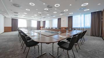 A conference room with a long table, chairs, and a modern ceiling design.