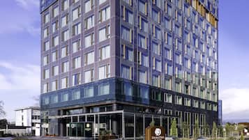 Een modern hotel met een glazen gevel, meerdere verdiepingen en een bord met daarop 'DOUBLETREE'.
