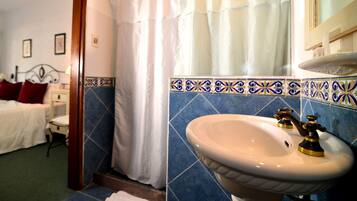 A bathroom with a white sink, blue tiles, and a shower curtain.