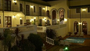 A two-story building with a pool, outdoor seating, and multiple balconies. - Don Antonio Posada (Colonia del Sacramento)