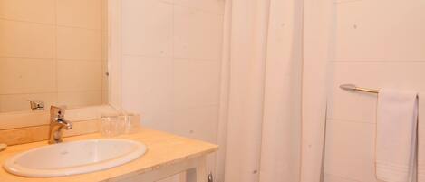 A bathroom with a sink, toilet, and shower curtain.