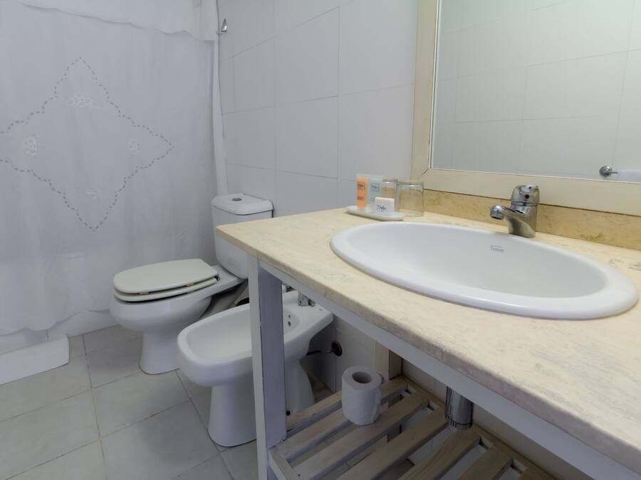 A bathroom with a white sink, toilet, and bidet.