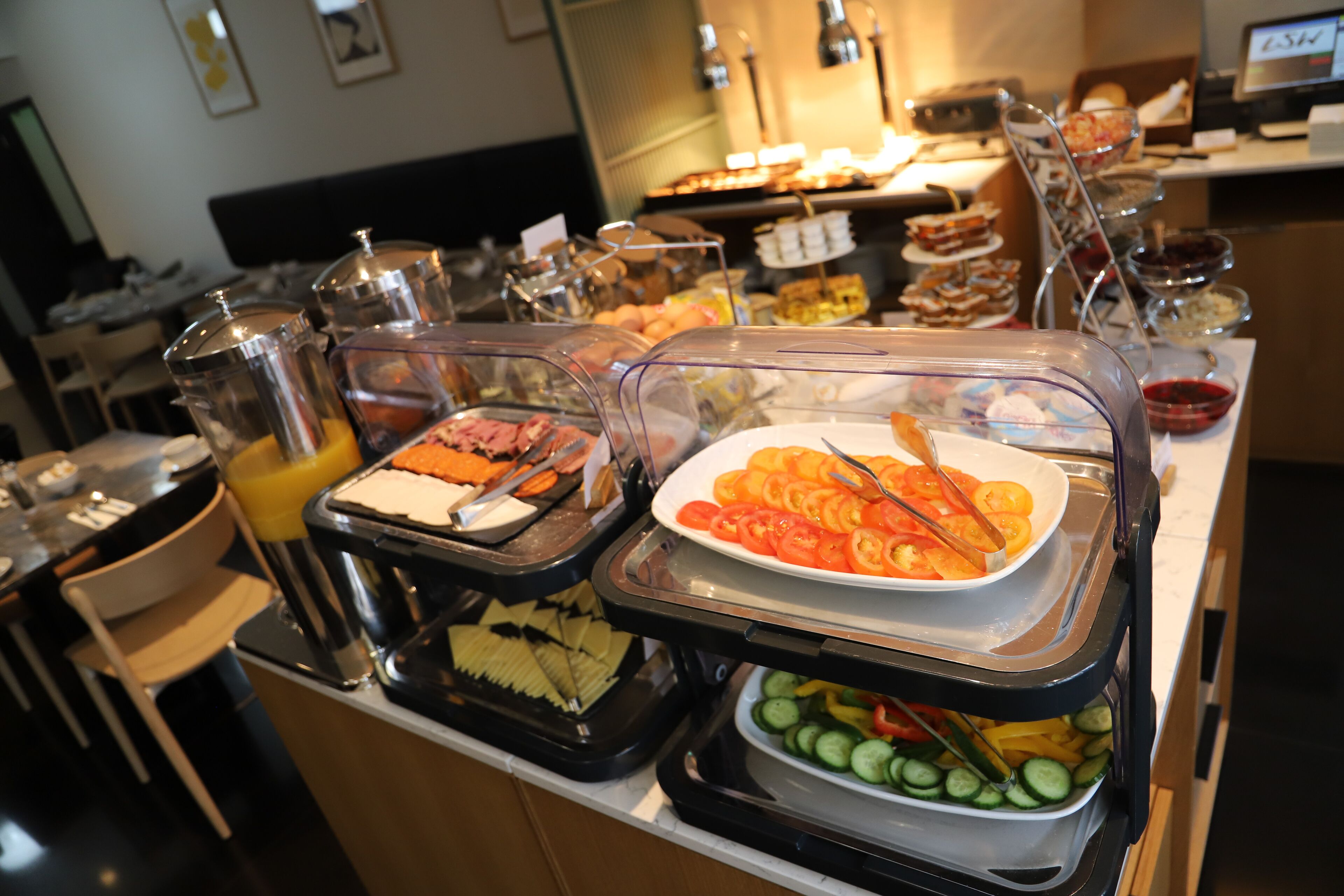 Un buffet con diversi piatti, tra cui pomodori a fette, cetrioli e un'ampia scelta di altre specialità.